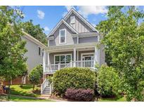 Charming two-story home featuring a cozy front porch and lush, mature landscaping at 220 W Winmore Ave, Chapel Hill, NC 27516