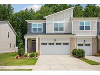 Charming two-story townhouse with a two-car garage and beautiful landscaping in front at 273 Millennium Dr, Pittsboro, NC 27312