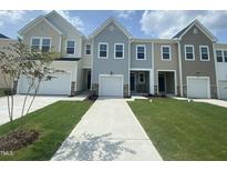 Beautiful townhomes with well-maintained lawns and driveways on a sunny day at 369 Thompson Overlook Way, Smithfield, NC 27577