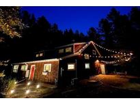 Charming exterior view of a home illuminated with warm string lights at night at 3822 Chicken Bridge Rd, Pittsboro, NC 27312