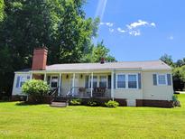 Charming single-story home with a brick chimney, inviting front porch, and well-maintained lawn at 411 W Raleigh St, Siler City, NC 27344
