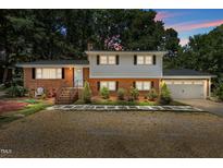 Charming two-story home with a brick facade, white trim, and well-manicured landscaping at 4404 Susan Dr, Raleigh, NC 27603