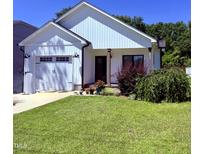 Charming white home with a well-manicured lawn and an attached two-car garage at 451 N Lincoln St, Benson, NC 27504