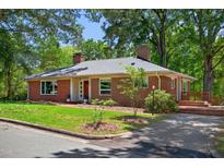Charming brick home featuring a well-manicured lawn and mature trees, providing a peaceful and inviting curb appeal at 503 Tarleton Ave, Burlington, NC 27215