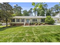 Charming single-story home with manicured lawn and neatly landscaped front yard, exuding classic curb appeal at 821 Van Thomas Dr, Raleigh, NC 27615