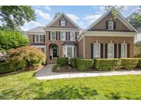 Charming brick home with manicured landscaping, black shutters, and a welcoming front entrance at 9021 Winged Thistle Ct, Raleigh, NC 27617
