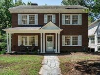 Charming brick home featuring a covered front porch with white columns and classic shutters at 907 W Johnson St, Raleigh, NC 27605