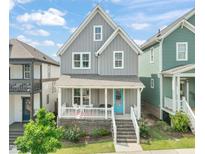Charming two-story home featuring a welcoming front porch and stylish, gray siding at 1006 Whistler St, Durham, NC 27713
