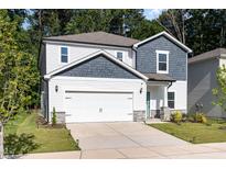Charming two-story home featuring a 2-car garage, white siding and a welcoming, covered entryway at 1113 Umstead Grove Way, Durham, NC 27712