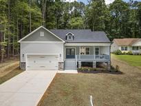 Charming new home with a covered porch, 2-car garage and a beautiful landscaped front yard at 113 Pueblo Dr, Louisburg, NC 27549