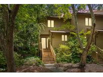 Charming townhouse with wood siding, lush landscaping, and inviting wooden staircase at 113 Twisted Oak Pl, Durham, NC 27705