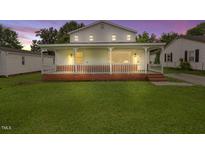 Charming two-story home with a welcoming front porch and a well-maintained lawn at 163 W Lillington St, Angier, NC 27501
