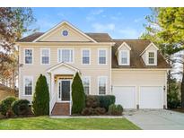 Charming two-story home featuring a well-maintained lawn, mature landscaping, and an attached two-car garage at 165 Sutherland Dr, Franklinton, NC 27525