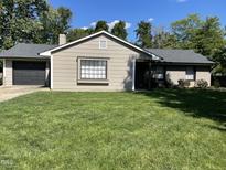 Charming single-story home with a well-manicured lawn, neutral-colored exterior, and dark roof at 205 Woodhaven Dr, Burlington, NC 27217