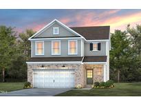 Charming two-story home with a brick facade, two-car garage, and manicured lawn, perfect for Gathering living at 2309 Edenberry Ln, Fuquay Varina, NC 27526
