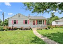 Charming home with pink shutters and a well-manicured lawn creates an inviting curb appeal at 302 Bradley St, Burlington, NC 27215