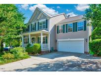 Charming two-story home with attached garage, manicured lawn, and inviting front porch perfect for southern comfort at 3217 Enchanting Way, Raleigh, NC 27616
