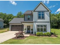 Two-story home with a well-manicured lawn, attached garage, and a welcoming front porch and tidy landscaping at 335 Glenn St, Franklinton, NC 27525