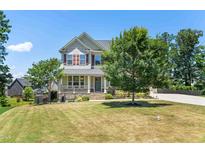 Charming two-story home featuring a manicured lawn and inviting front porch, perfect for suburban living at 3504 Regent Pines Dr, New Hill, NC 27562