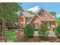 Charming brick home with manicured landscaping, mature trees, and a welcoming entrance at 3606 Dairy Pond Pl, Durham, NC 27705