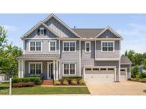 Charming two-story home with a well-maintained lawn, attached garage, and inviting curb appeal at 408 Brierley Dr, Apex, NC 27523