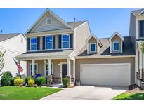 Charming two-story home featuring a welcoming front porch, attached garage, and meticulously landscaped front yard at 437 Excalibur Dr, Morrisville, NC 27560
