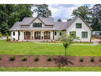Inviting exterior of a bright, white home with a manicured lawn and charming walkway to the front door at 4412 Pamlico Dr, Raleigh, NC 27609