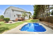 Inviting backyard featuring a sparkling in-ground pool, patio with fire pit, deck, and lush landscaping at 626 Toledo Ct, Rolesville, NC 27571