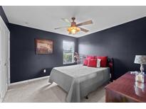 Comfortable bedroom with a ceiling fan, natural light, and dark-colored walls at 7 Faircroft Ct, Durham, NC 27703