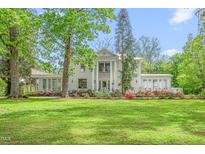 Stately two-story home boasts a columned facade, covered porch, and manicured landscaping at 7920 E Washington St, Mebane, NC 27302