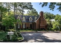 Charming brick home with mature landscaping, dormer windows, and a prominent chimney, showcasing classic architectural details at 815 Marlowe Rd # 10, Raleigh, NC 27609