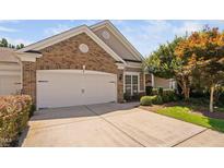Charming brick home featuring a two-car garage and well-manicured landscaping at 112 Sabiston Ct, Cary, NC 27519