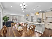 Bright kitchen with stainless appliances, granite counters, hardwood floors and a large kitchen island at 1313 Littlehills Dr, Apex, NC 27523