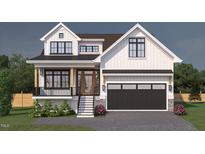 Charming two-story home with a black metal roof, white siding, and a black garage door at 135 Gary Rd, Carrboro, NC 27510