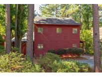 View of the home's exterior showing the wooded surroundings and rustic color at 1409 Valley, Durham, NC 27707