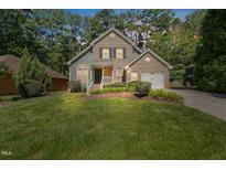 Charming two-story home with a brick facade, well-manicured lawn, and mature landscaping at 217 Dalmeny Dr, Cary, NC 27513