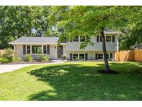 Charming two-story home with gray brick and siding, mature trees, and well-maintained landscaping at 2317 Bertie Dr, Raleigh, NC 27610