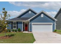Charming single-story home with blue siding, a two-car garage, manicured lawn and bright red front door at 265 Purple Aster St, Youngsville, NC 27596