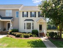 Charming two-story townhome with manicured lawn and beautiful front garden near a serene lake at 400 Nottinghill Walk, Apex, NC 27502