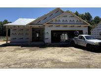 Unfinished home with Typar construction wrap, attached garage, and truck parked in the driveway at 4026 N Nc 581 Hwy, Kenly, NC 27542