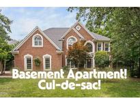 Traditional brick home with a well-manicured lawn and mature trees at 409 Englewood Dr, Chapel Hill, NC 27514