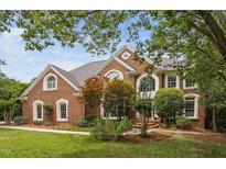 Beautiful brick home featuring manicured landscaping, architectural design, and large windows at 409 Englewood Dr, Chapel Hill, NC 27514