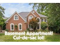 Charming brick home featuring a well-manicured lawn, mature trees, and an inviting front entrance at 409 Englewood Dr, Chapel Hill, NC 27514
