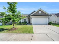 Charming single-story home featuring a well-manicured lawn, two car garage, and classic architectural details at 4102 Catfish Way, Durham, NC 27703