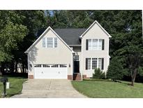 Traditional two-story home with a two-car garage, manicured lawn, and mature trees at 433 Turnberry Dr, Mebane, NC 27302