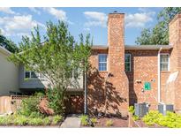 Brick townhome featuring a chimney, exterior storage closet, and sidewalk leading to the front door at 435 Summerwalk Cir # 435, Chapel Hill, NC 27517
