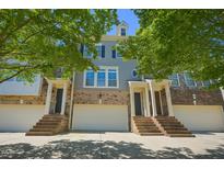 Charming townhome with brick facade, light gray siding, white garage door, and inviting staircase at 453 Panorama Park Pl, Cary, NC 27519