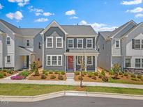Charming two-story gray home with red door and neatly landscaped front yard at 4716 Crescent Square St # 1314, Raleigh, NC 27616