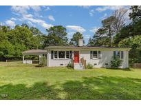 Charming one-story home with white brick, a red front door, and a well-manicured lawn at 500 Ellen Dr, Knightdale, NC 27545
