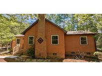 Charming single-Gathering home featuring wood siding, a brick chimney, and surrounded by mature trees at 5315 Mccormick Rd, Durham, NC 27713